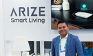 Joel Sandoval, Arize's National Director of Sales, posing in front of a smart tech demo booth.